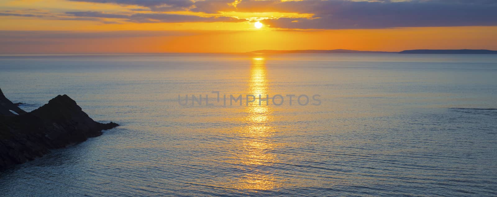 beautiful panoramic yellow sunset over loop head withcalm seass on the wild atlantic way in ireland