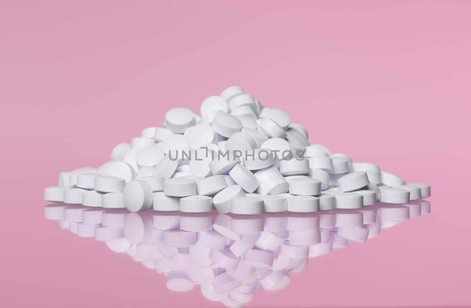 Stack of pills towards pink background