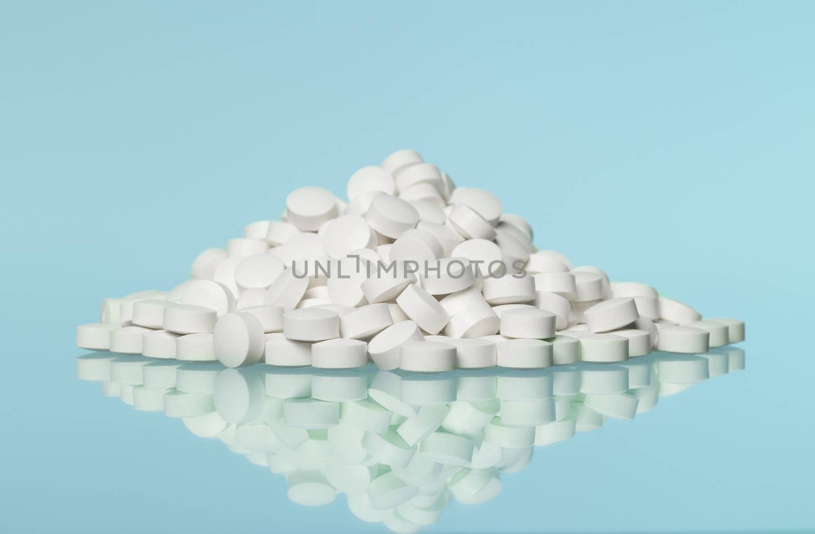 Stack of pills towards blue background by gemenacom