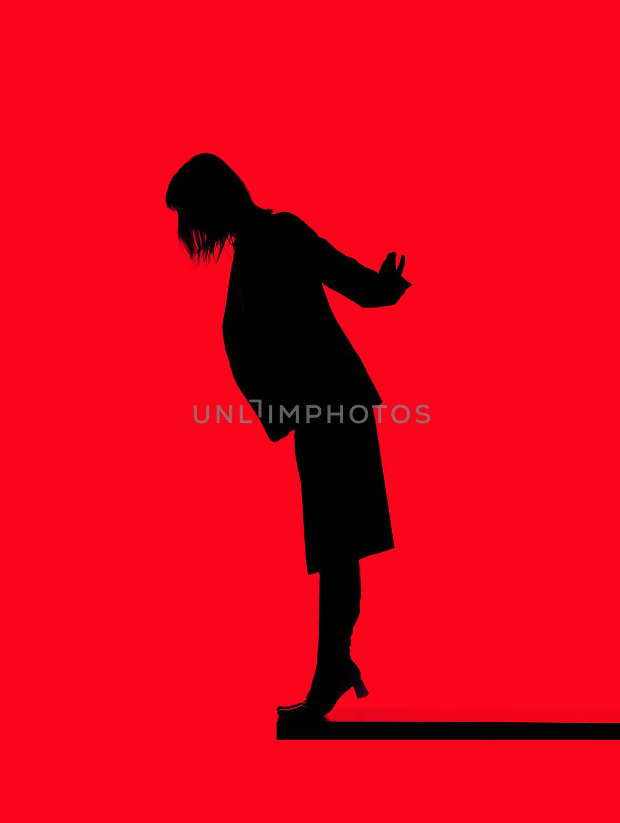 Silhouette of a woman close to fall down isolated on red background