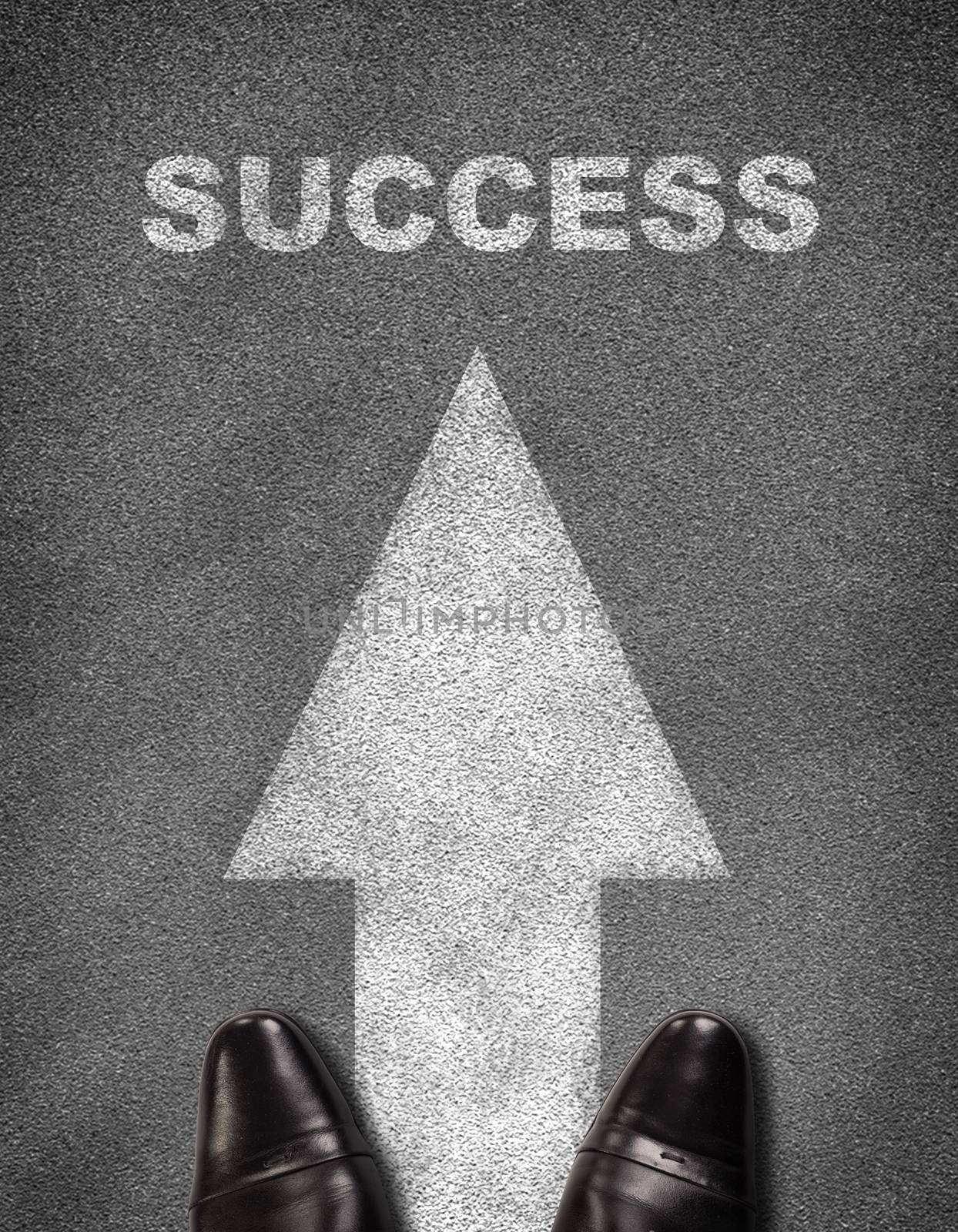 Shoes standing on asphalt road with arrow and word success by cherezoff