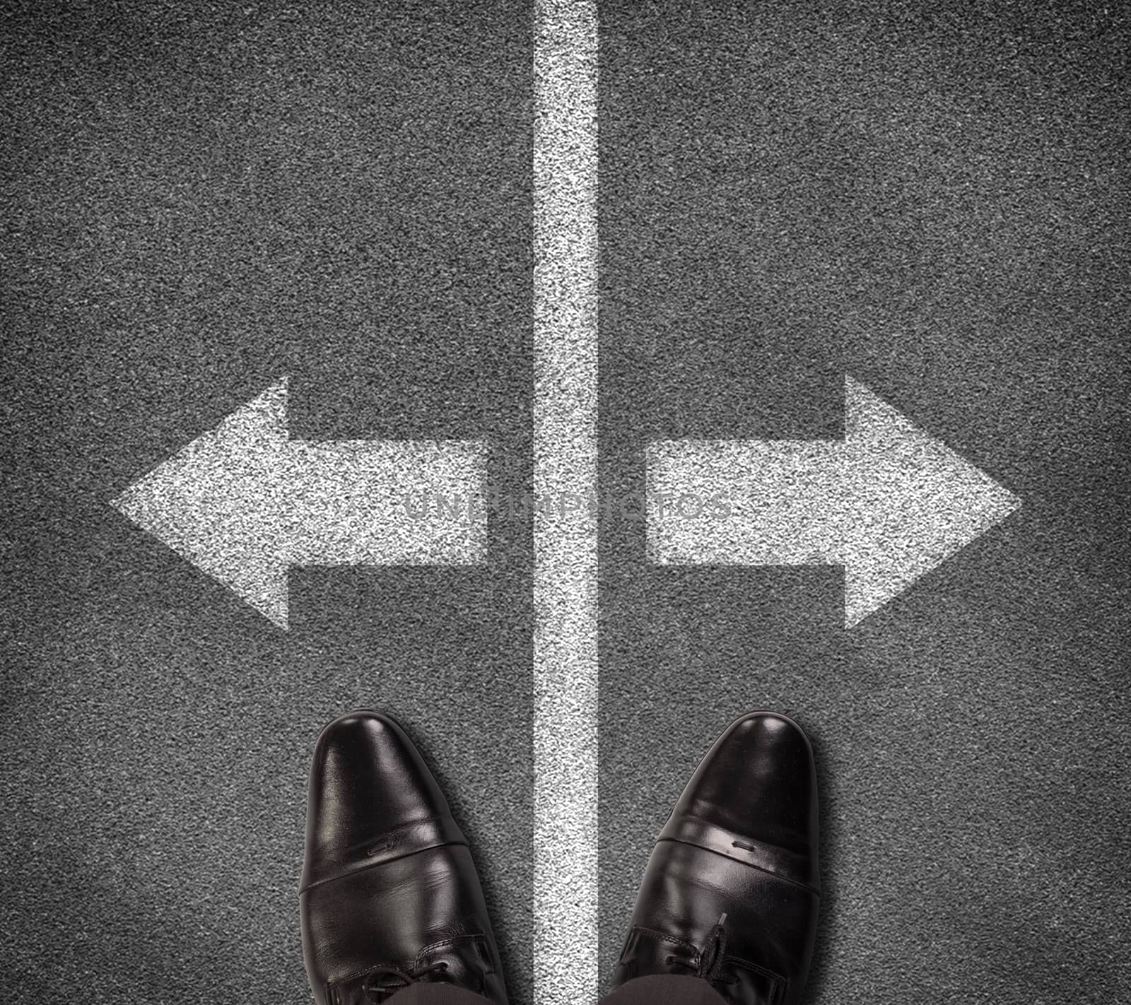 Shoes standing on asphalt road with two arrows and vertical line by cherezoff