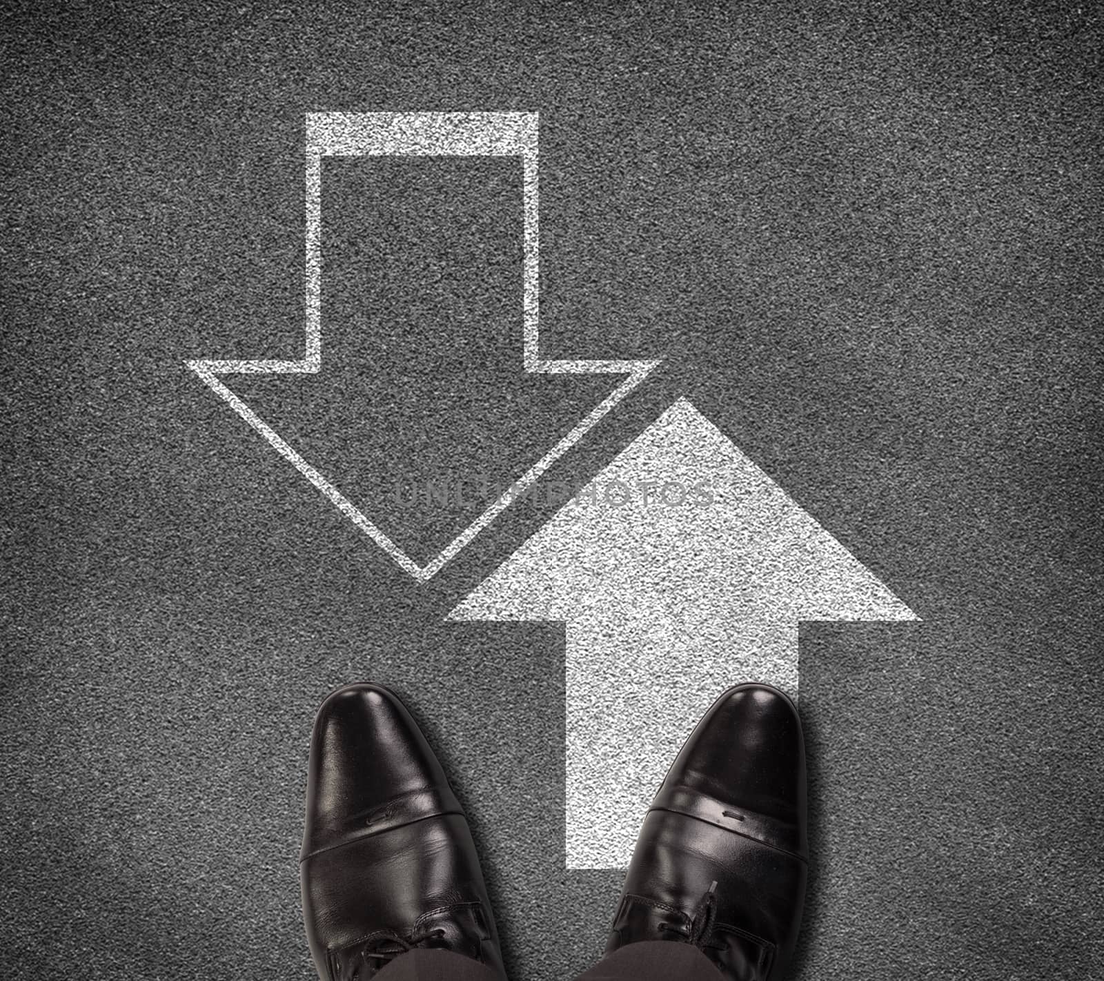 Top view of shoes standing on asphalt road with two up and down arrows. Business concept