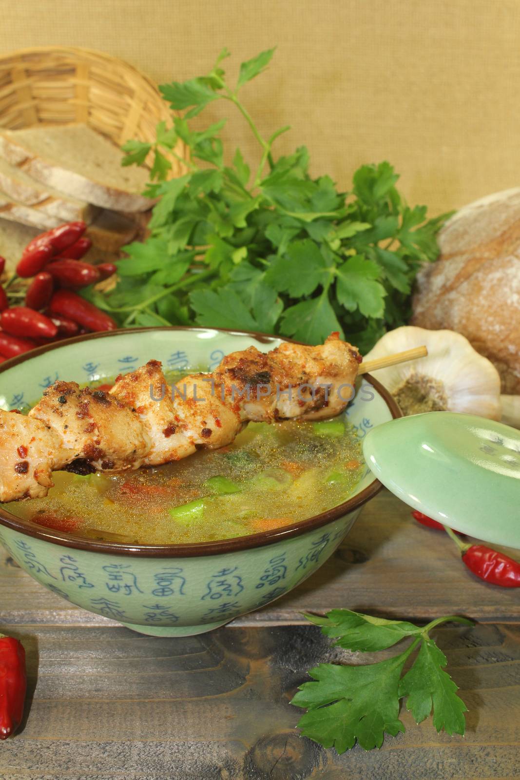 Chicken consomme with chicken skewers and vegetables by discovery