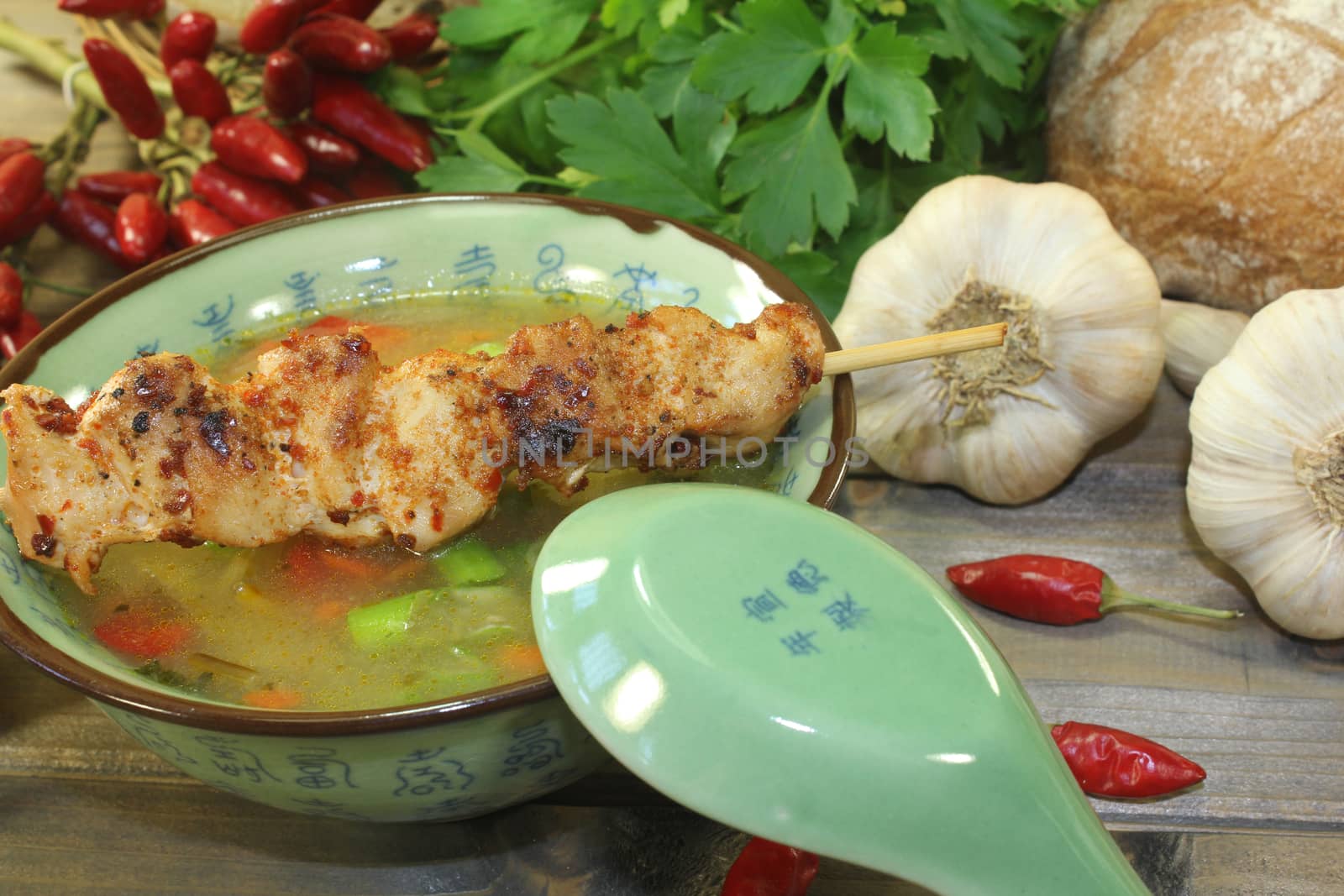 Poultry consomme with chicken skewers, vegetable and smooth parsley