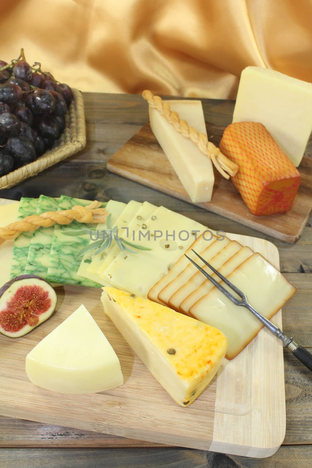 Slices of cheese with grapes, radishes, figs and fork