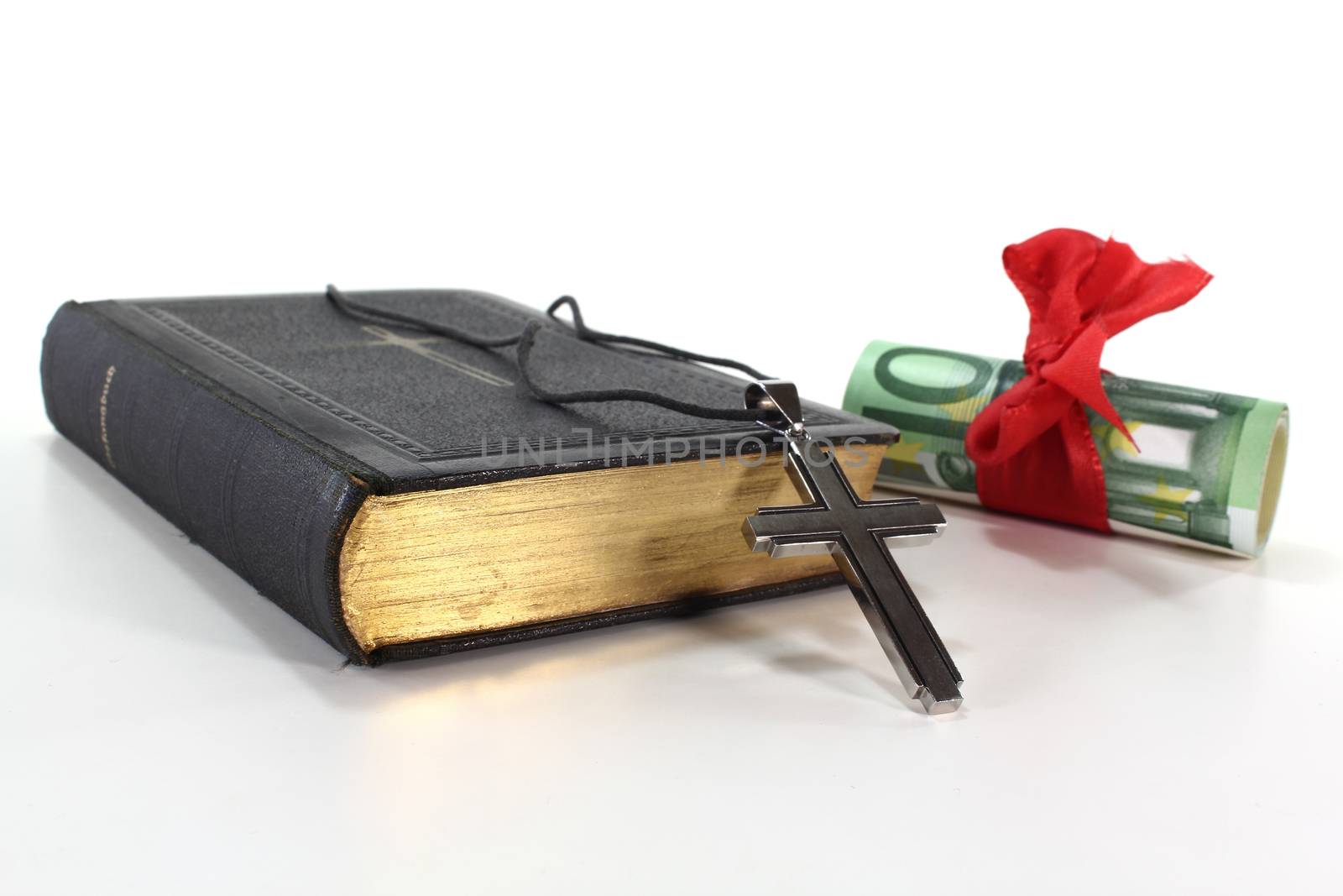 Hymnbook with Cross and hundreds of euro notes on a light background