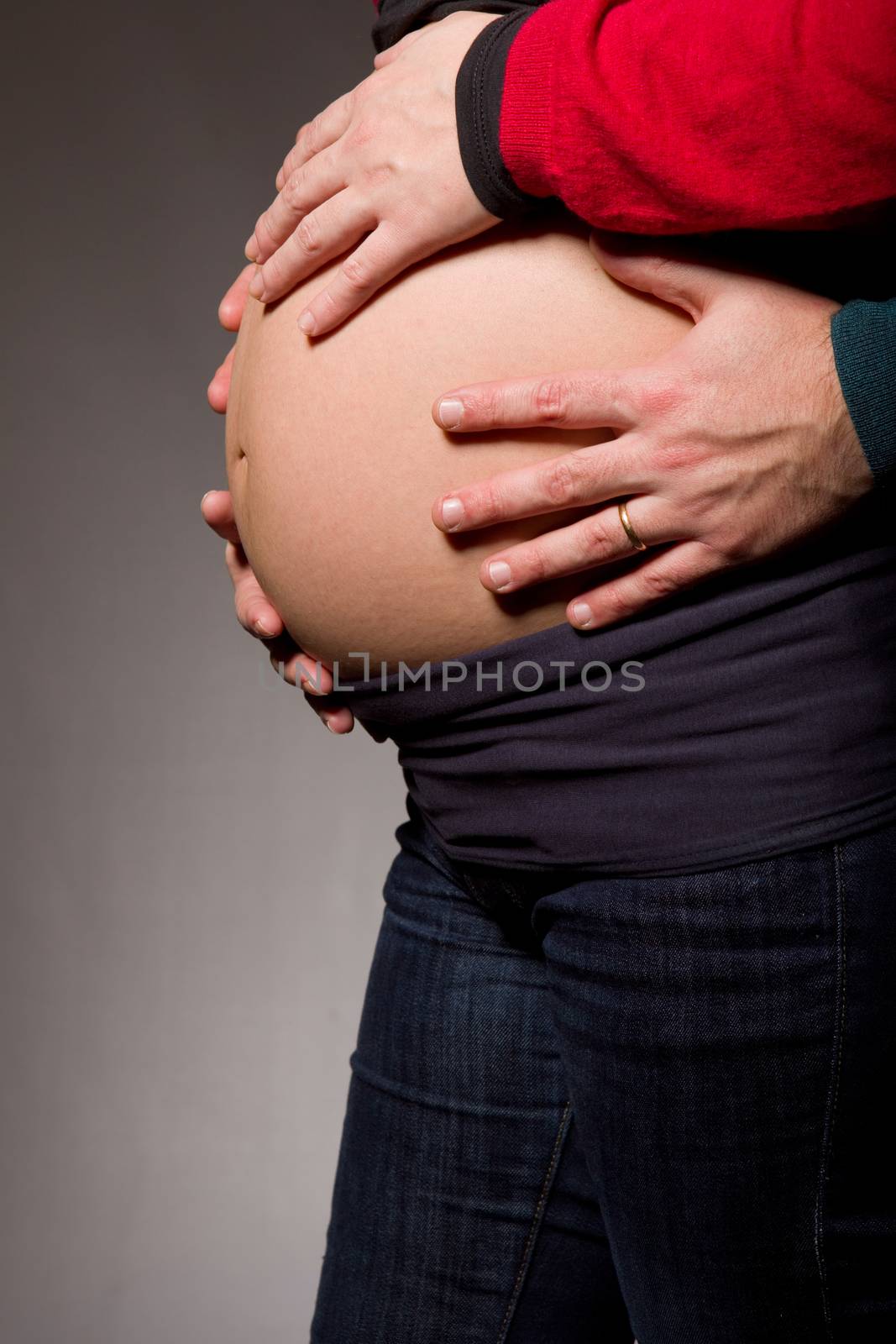 hands embrace a belly of the pregnant woman