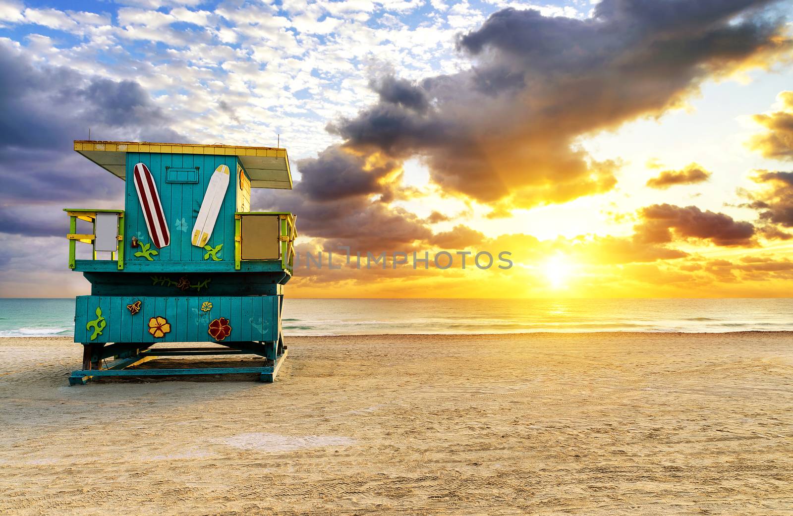 Miami South Beach sunrise with lifeguard tower and coastline with colorful cloud and blue sky. 