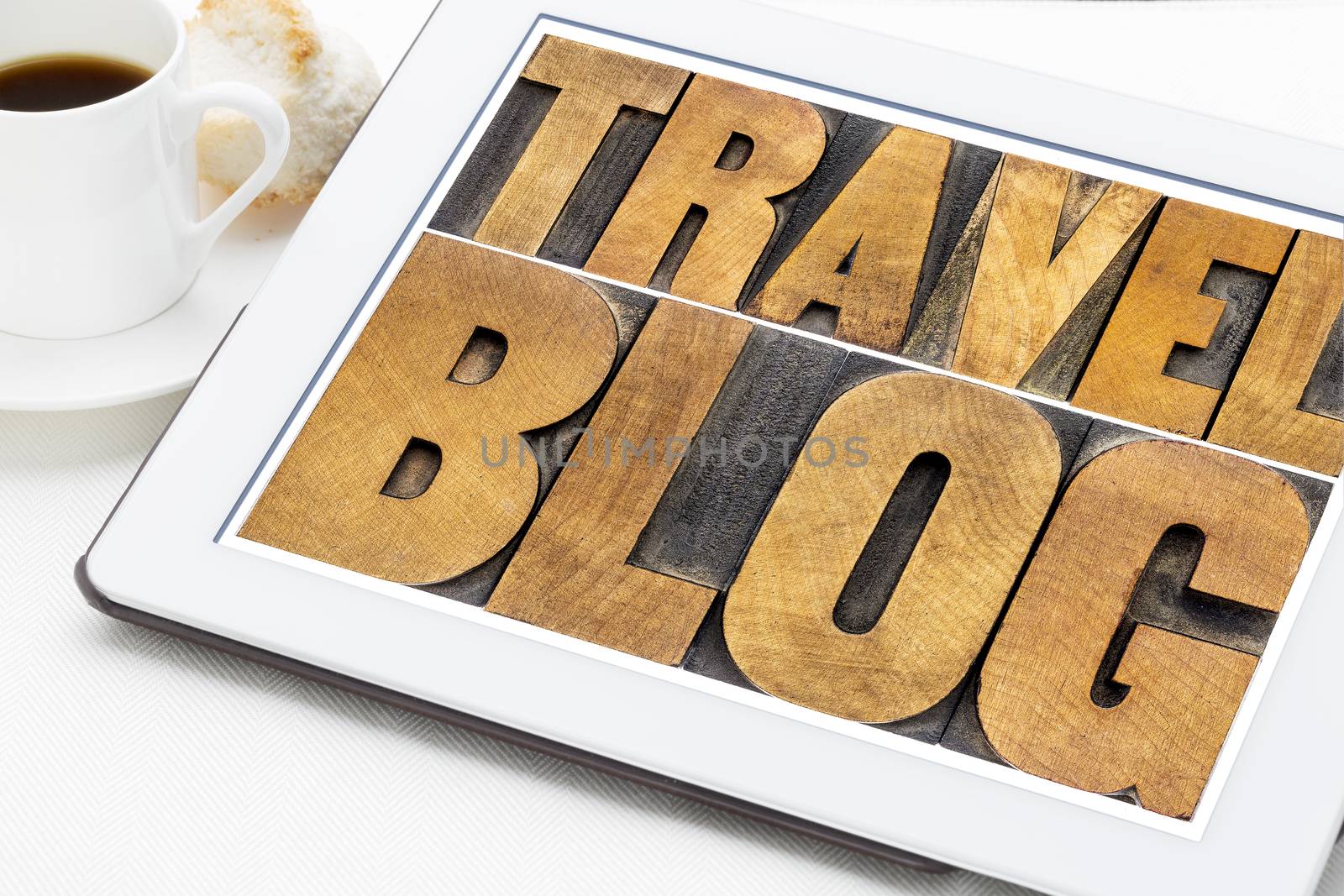 travel blog typography - text in letterpress wood type on a digital tablet with cup of coffee