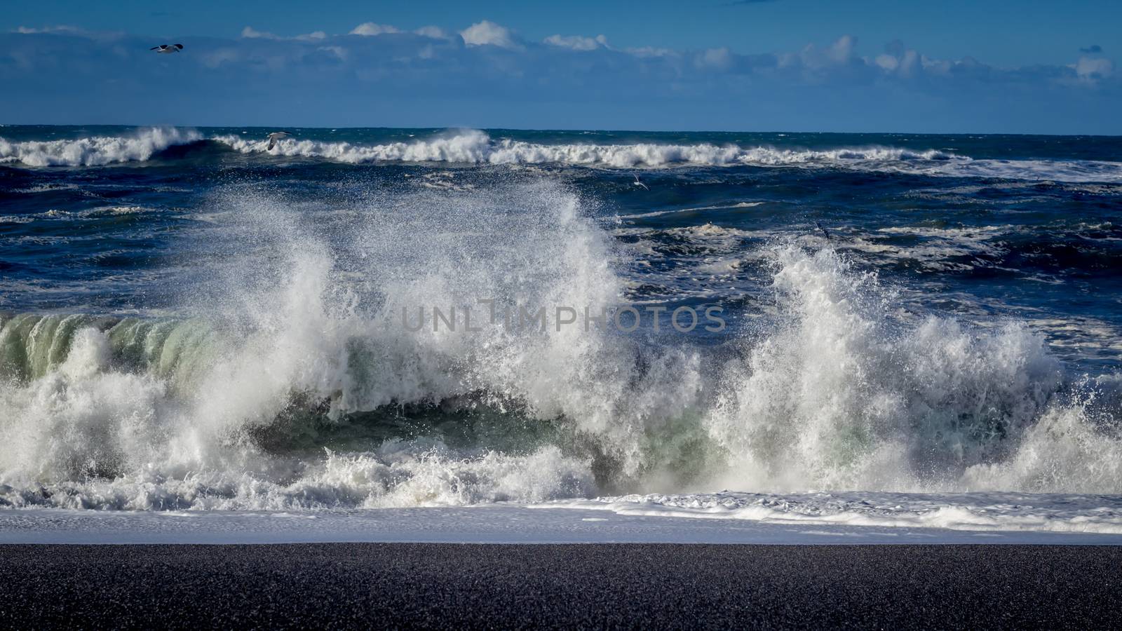 A large wave crashes on the Northern California coastline.