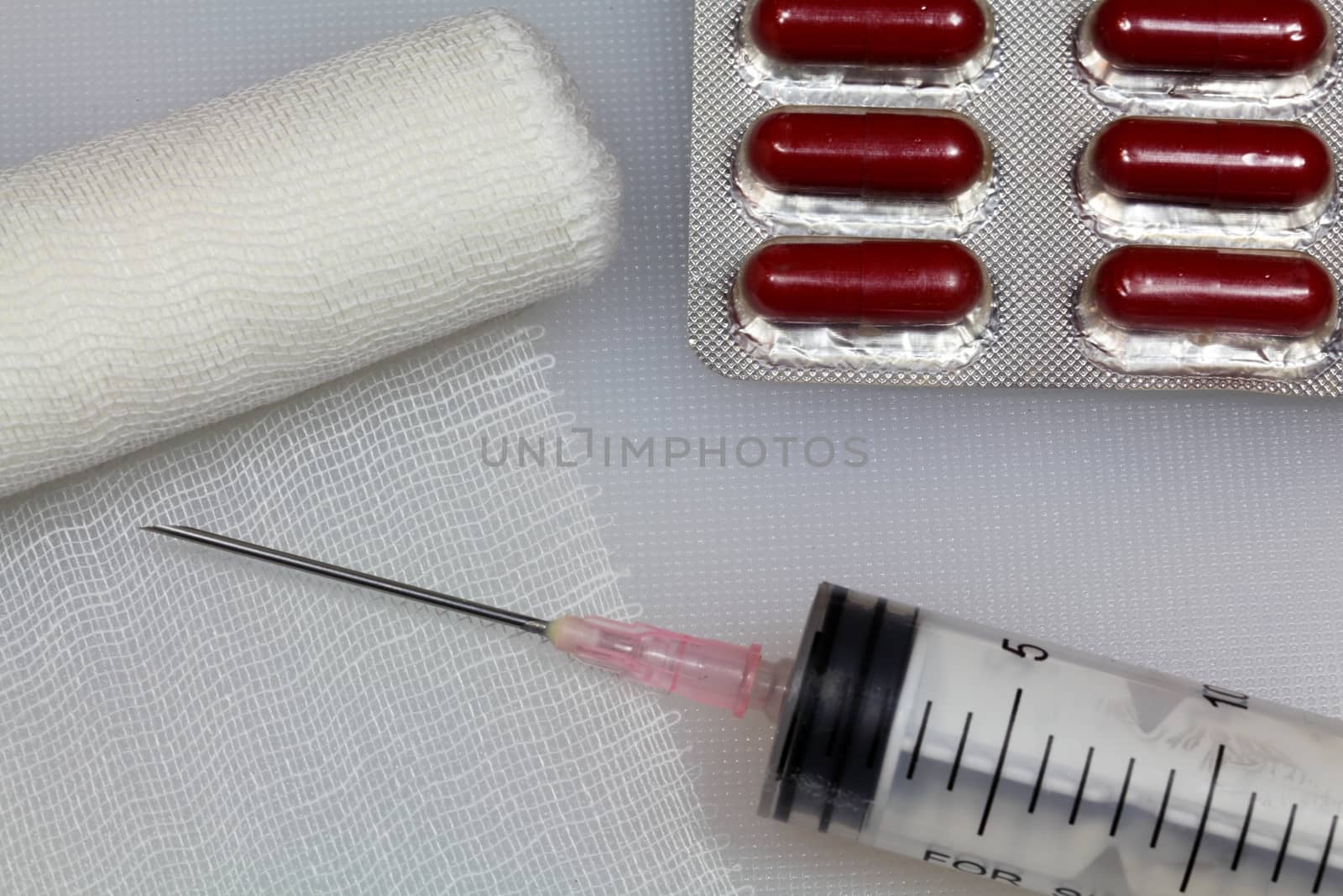 An injection needle with a bandage on a white background. 