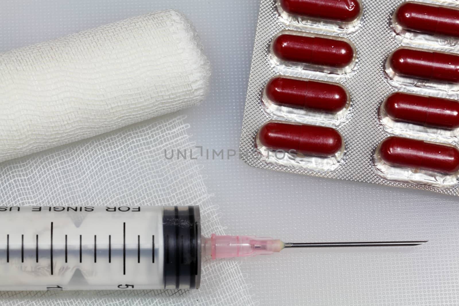 An injection needle with a bandage on a white background. 