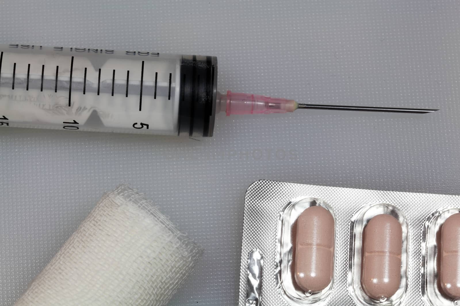 An injection needle with a bandage on a white background. 