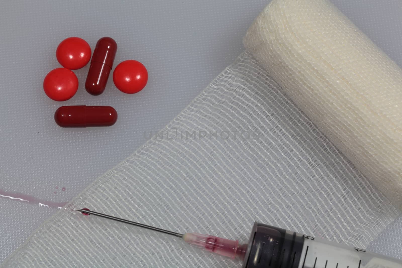 An injection needle with a bandage on a white background. 