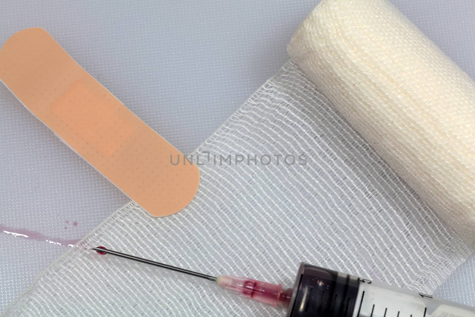 An injection needle with a bandage on a white background. 