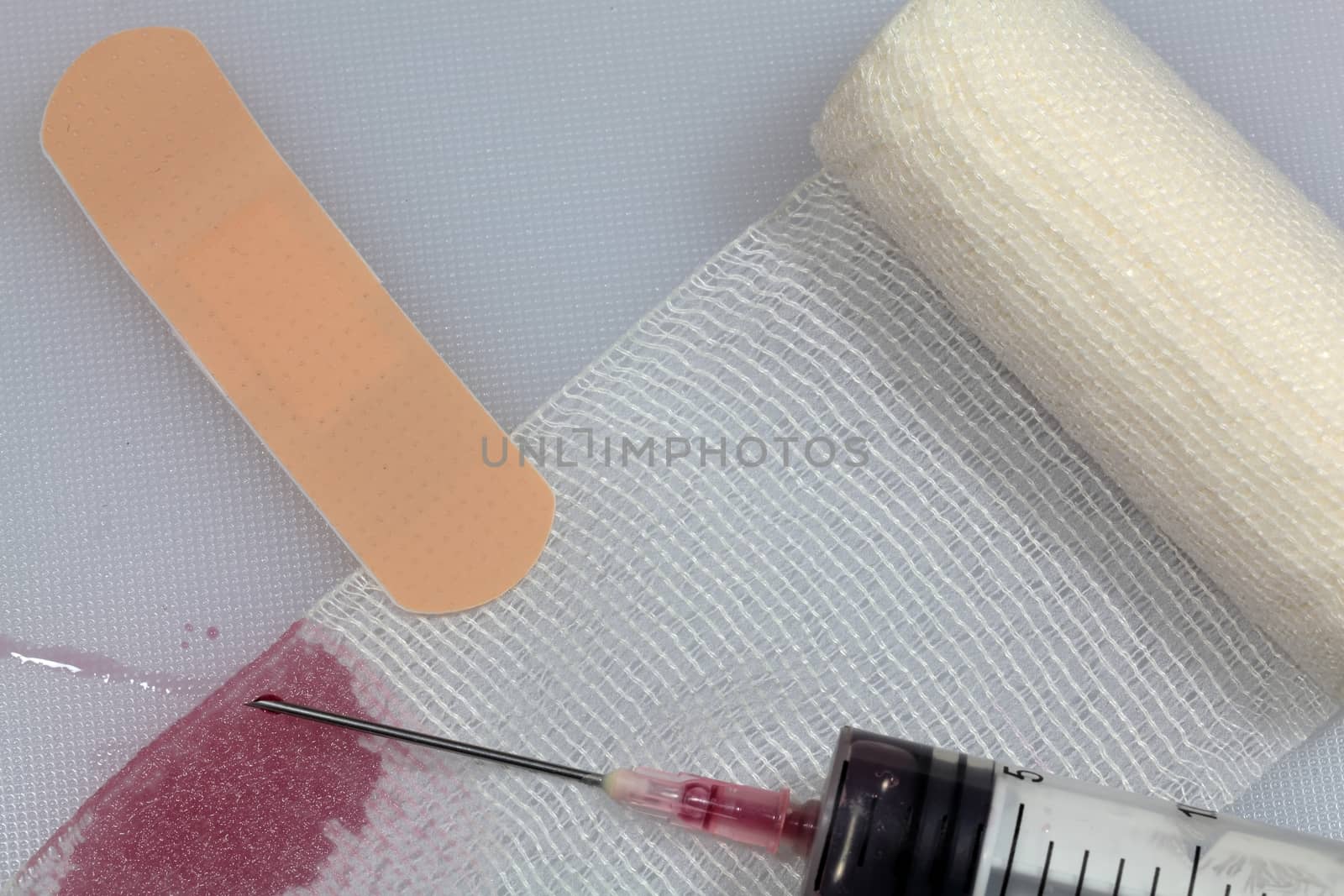 An injection needle with a bandage on a white background. 