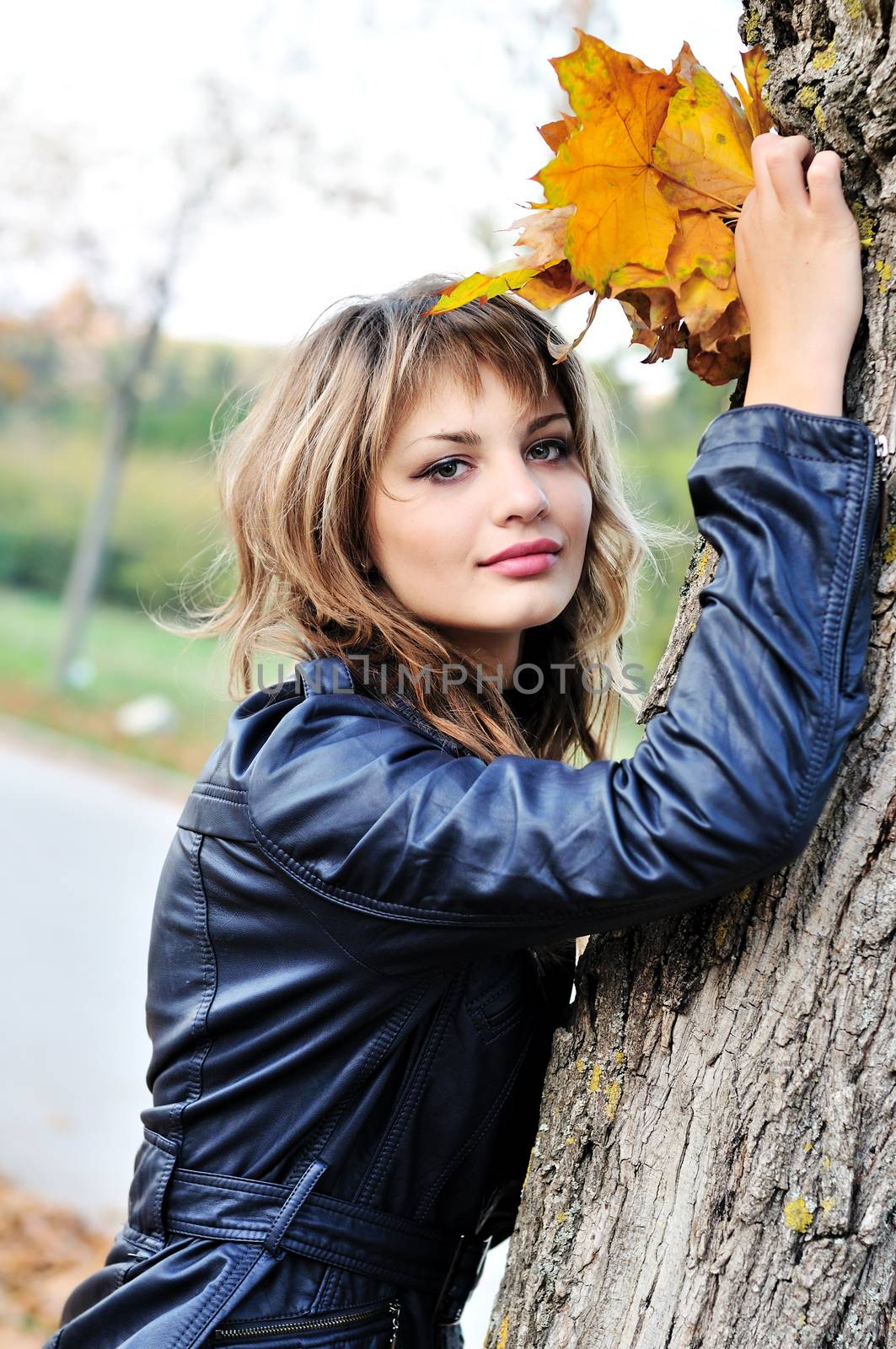 autumn  beautiful teen girl standing near the tree 