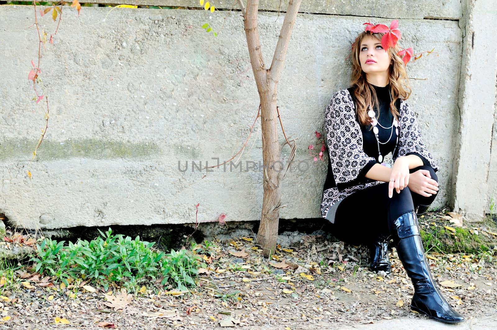 pensive teen girl sitting alone  near the wall