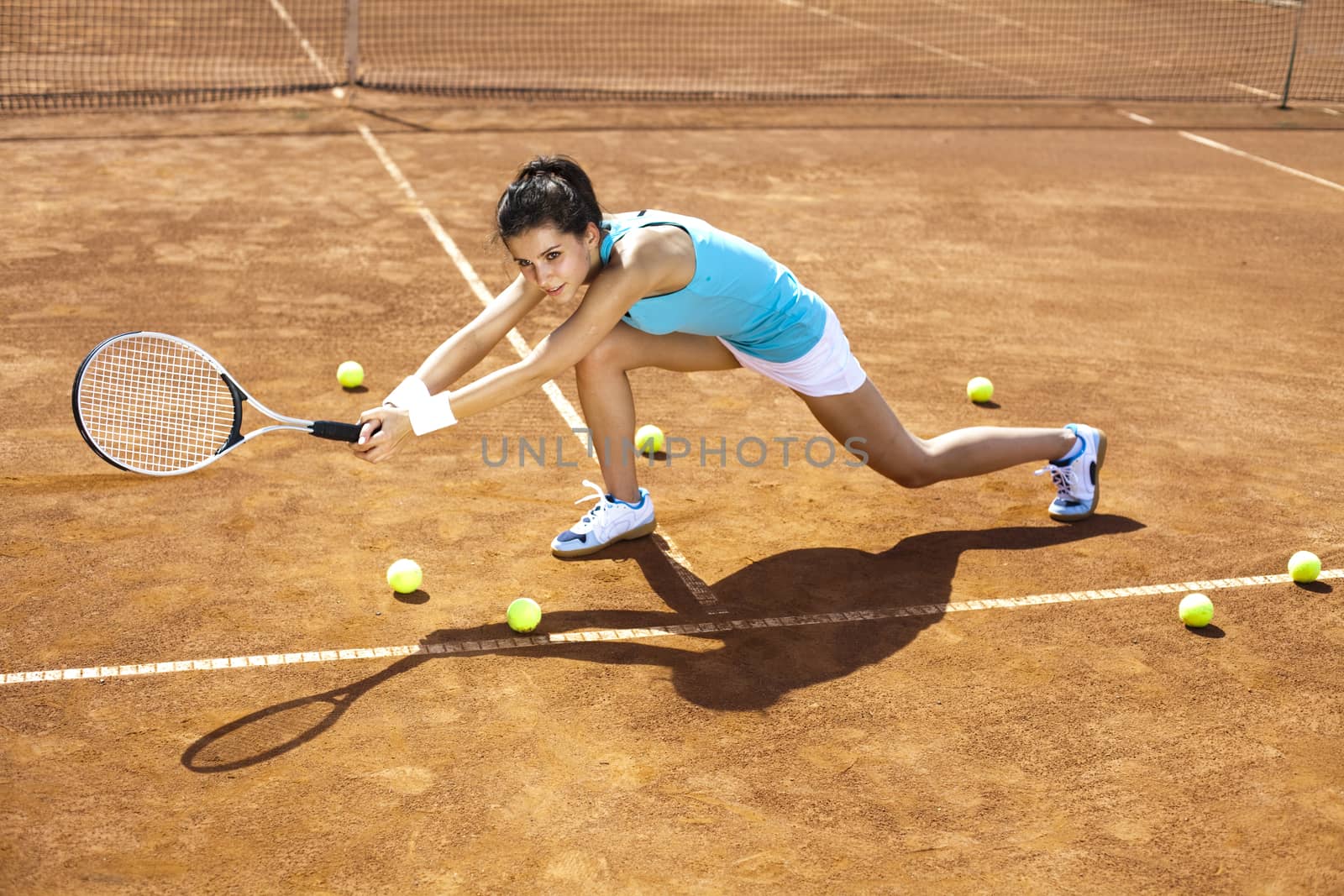 Woman playing tennis in summer by JanPietruszka