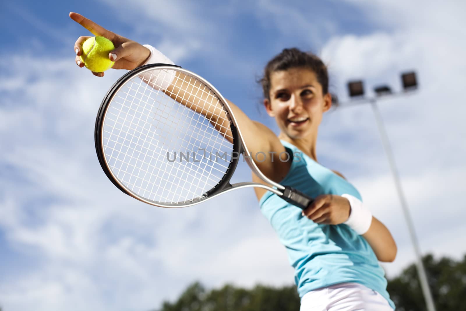 Young woman playing tennis, summertime saturated theme by JanPietruszka