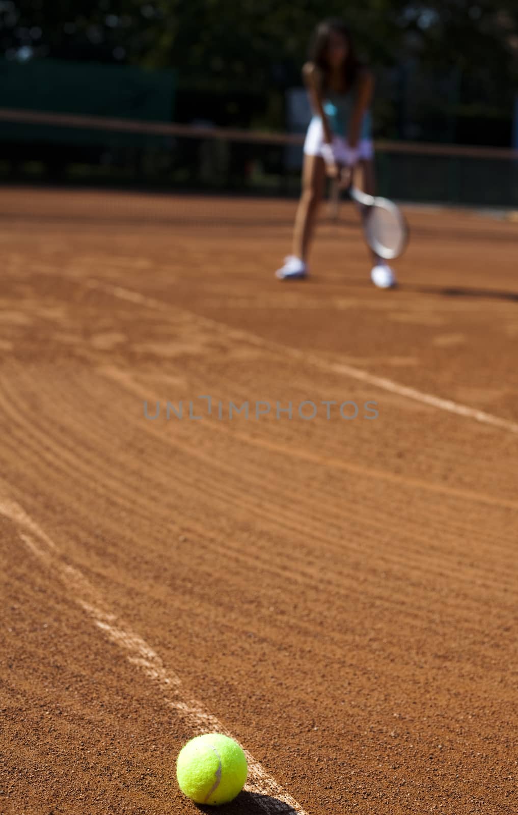 Young woman playing tennis, summertime saturated theme by JanPietruszka