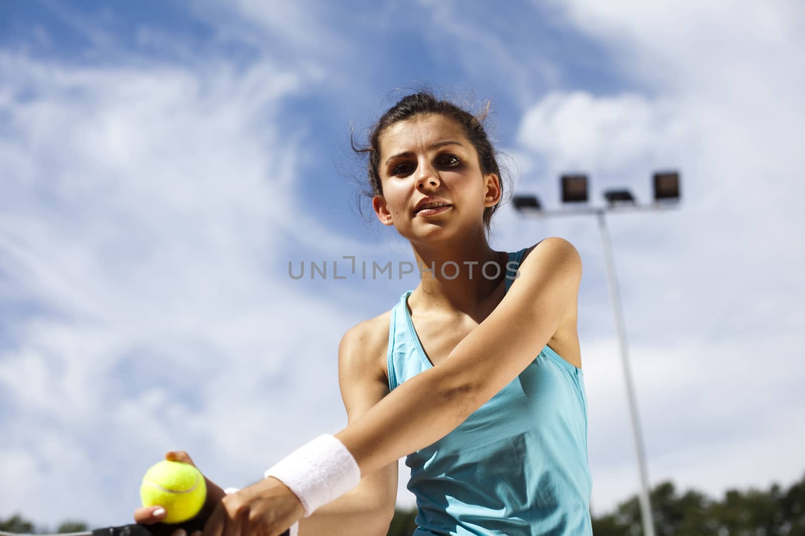 Young woman playing tennis, summertime saturated theme by JanPietruszka