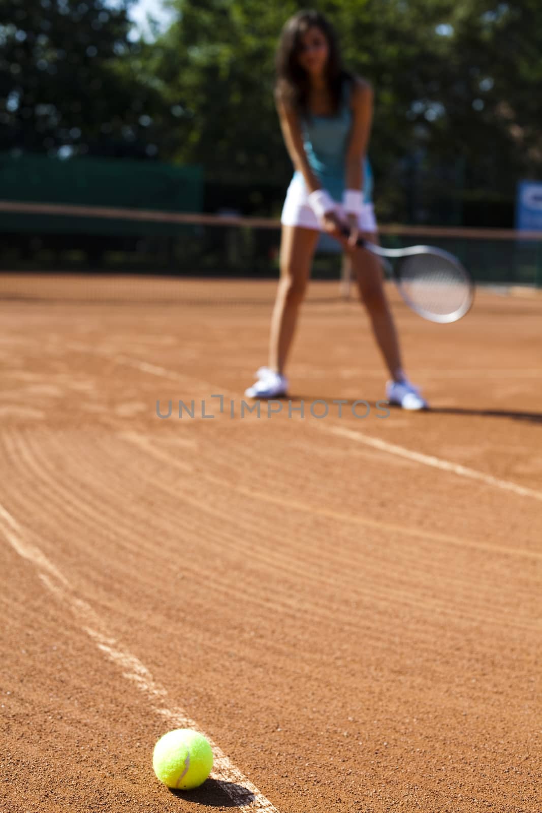 Young woman playing tennis, summertime saturated theme by JanPietruszka