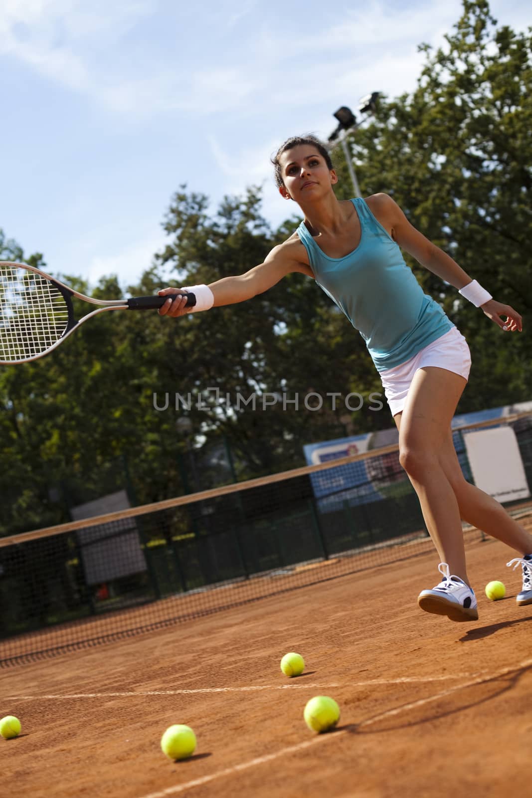 Young woman playing tennis, summertime saturated theme