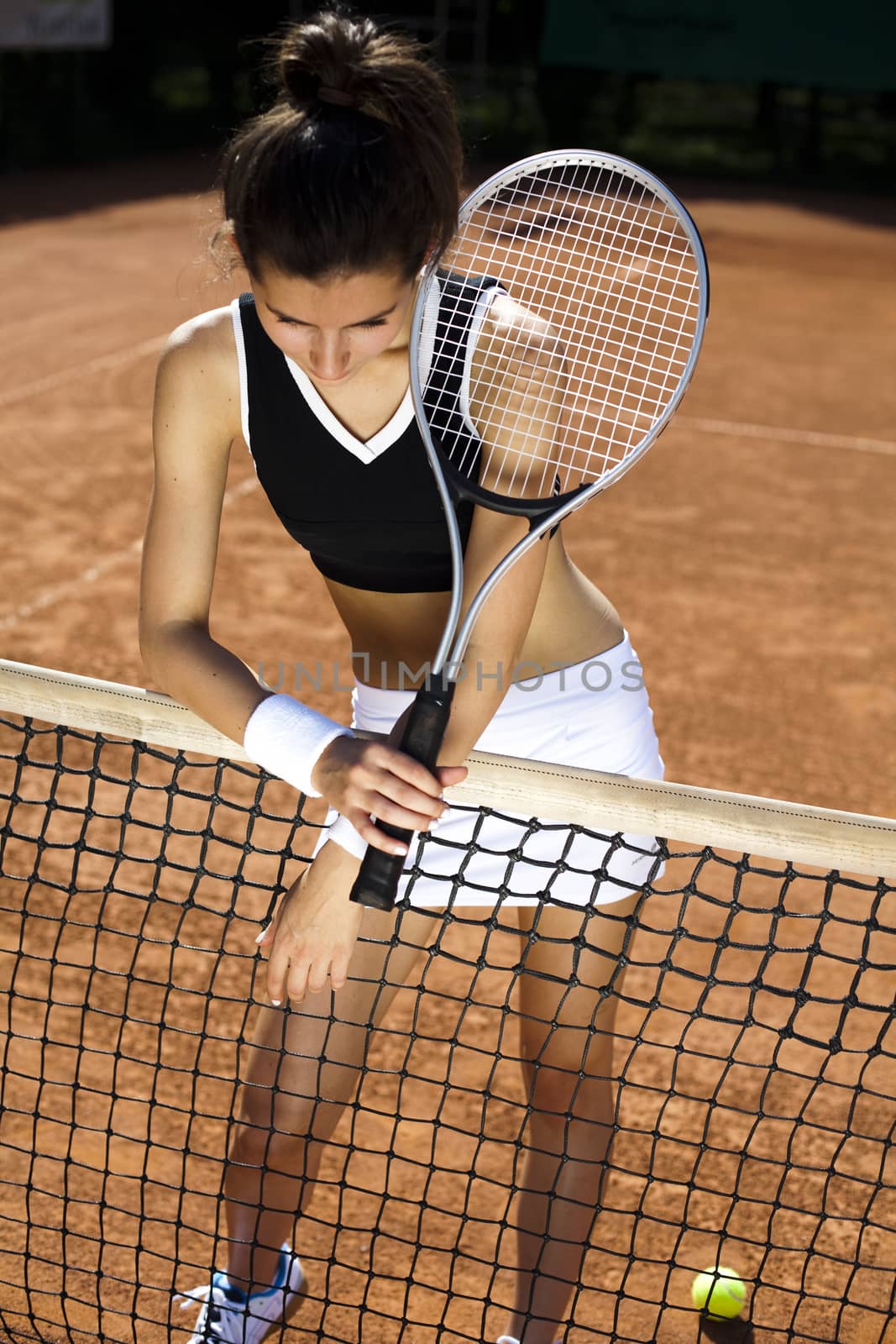 Young woman tennis player on the court by JanPietruszka