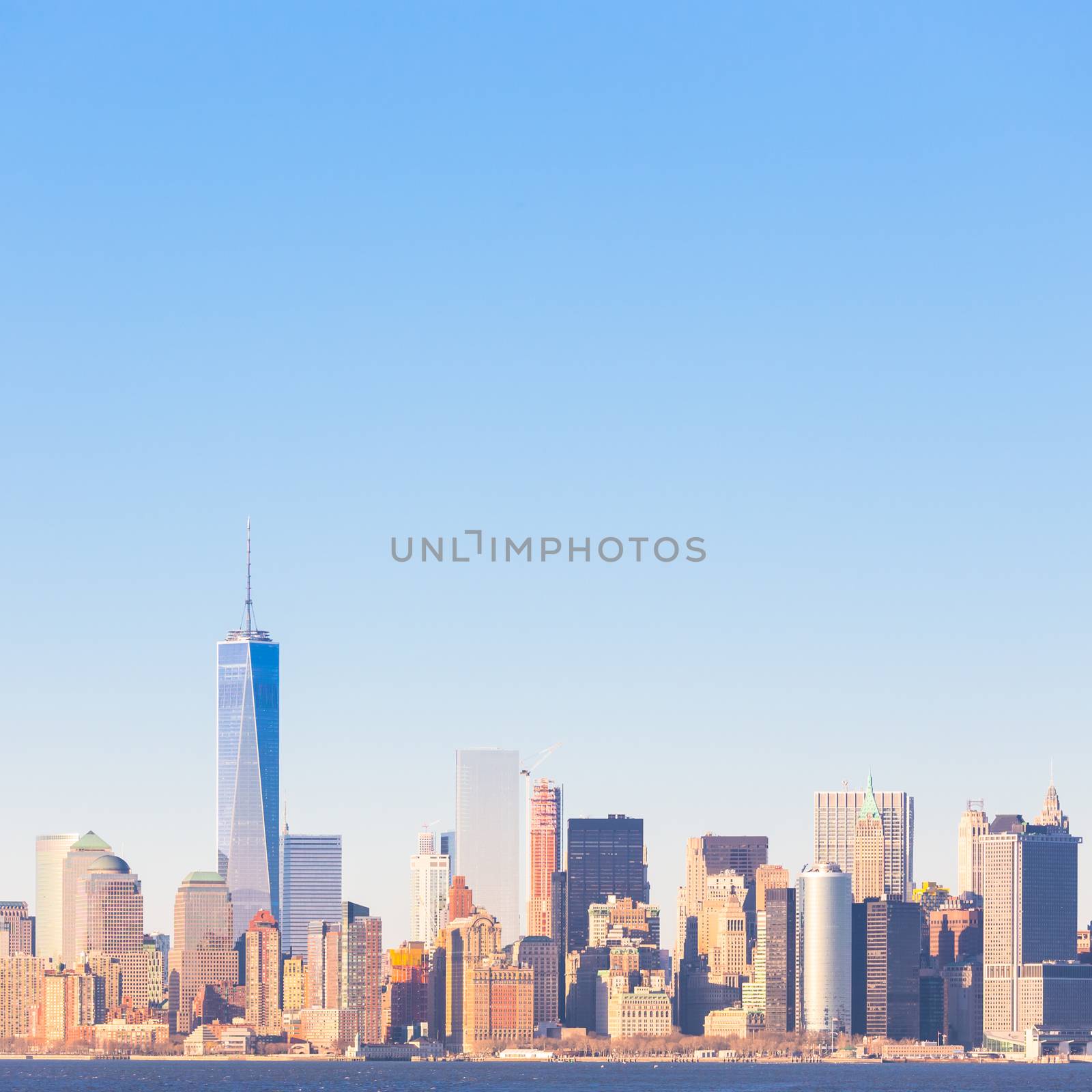 New York City Manhattan downtown skyline at sunset with skyscrapers illuminated over Hudson River panorama. Square composition, copy space.