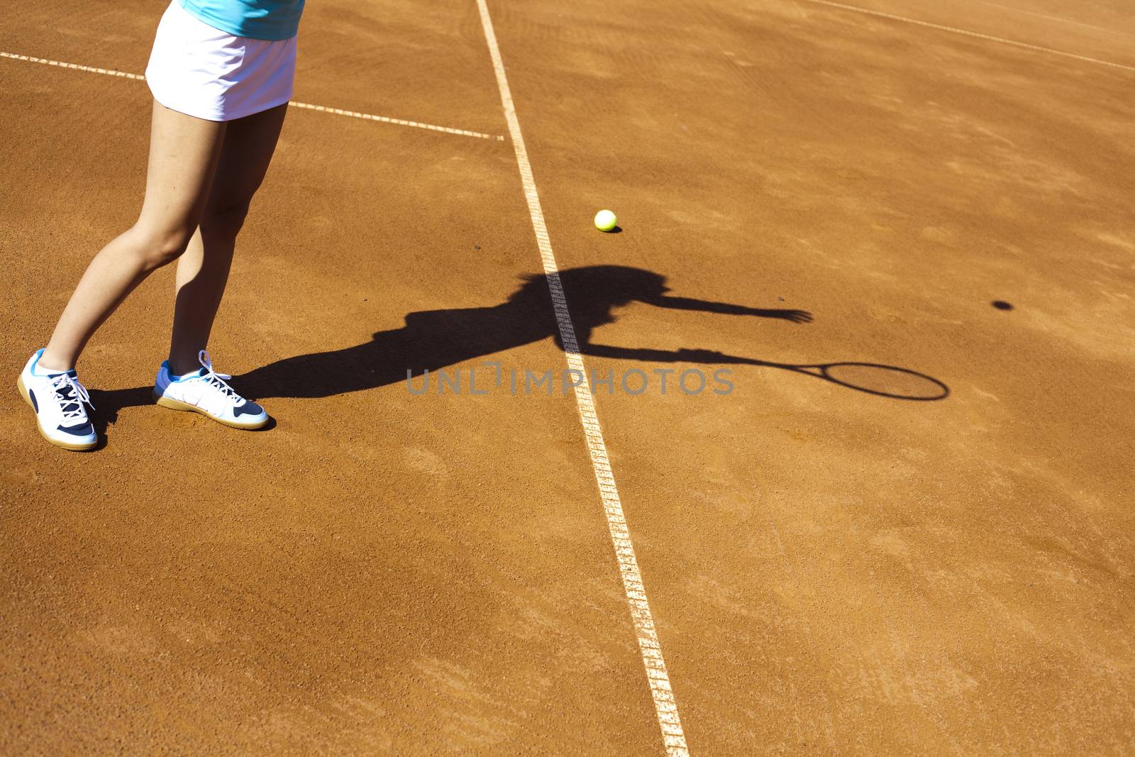 Girl playing tennis on the court by JanPietruszka