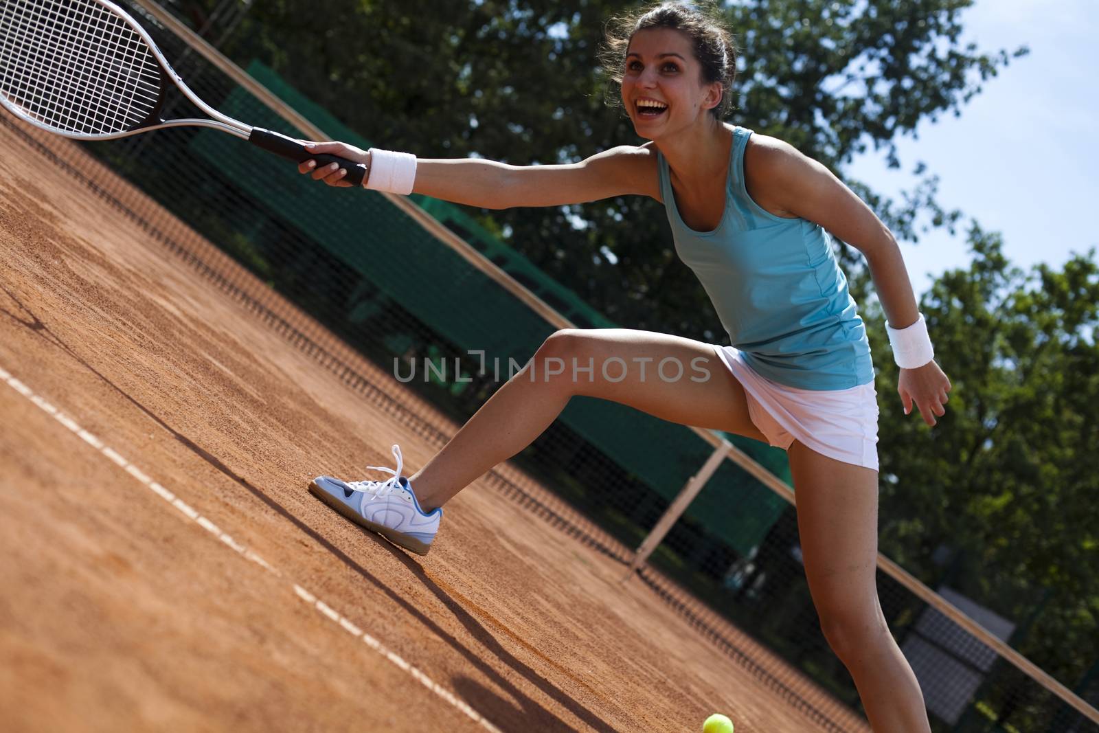 Girl playing tennis on the court by JanPietruszka