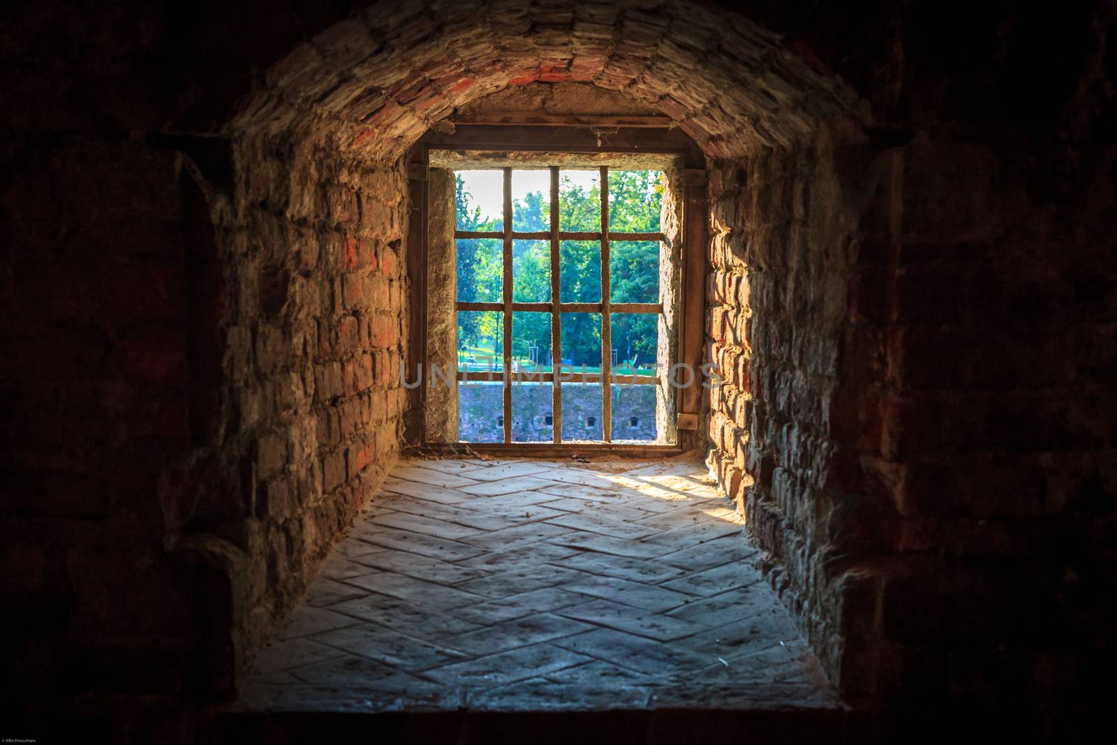 A window secured with iron bars of an old castle in Milan, Italy