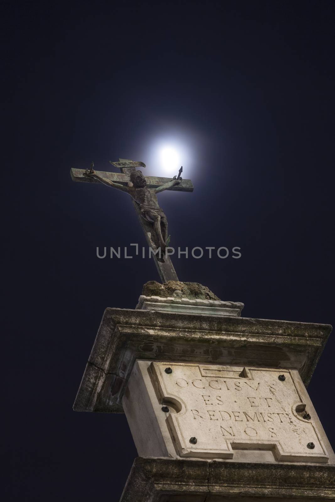 A statue of Jesus crucified illuminated by the moon, Monza, Italy