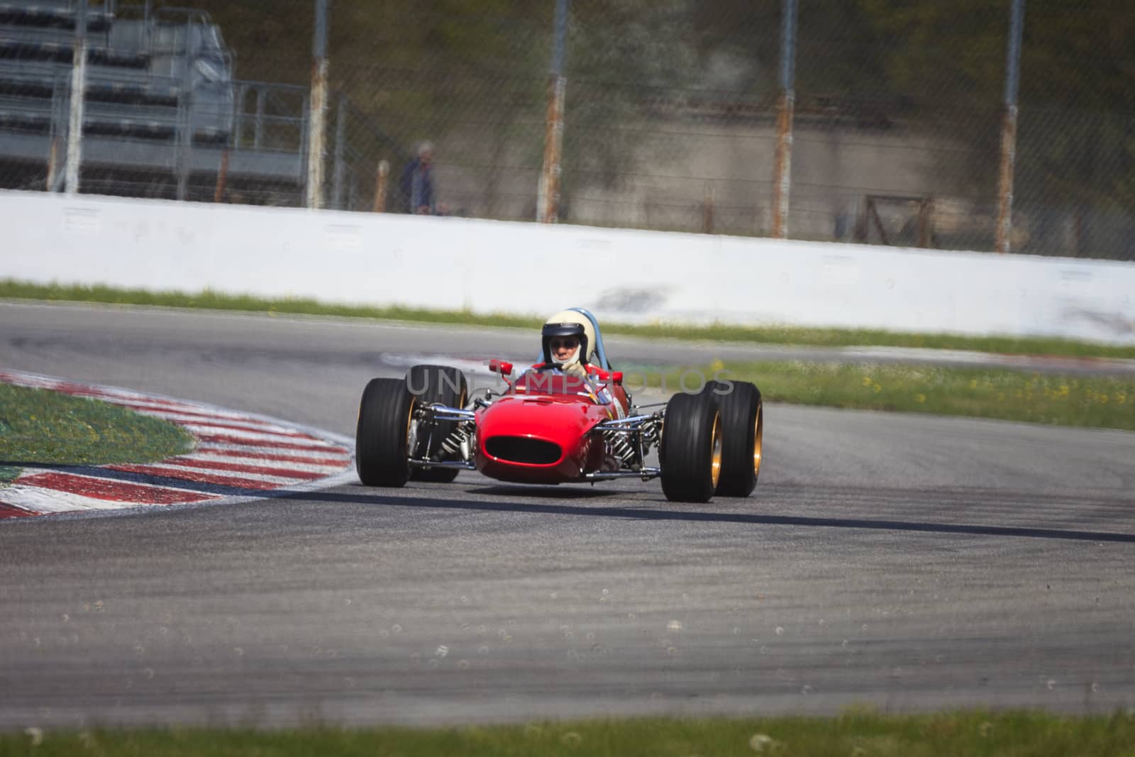 A red racing car running in the circuit of Monza, Italy