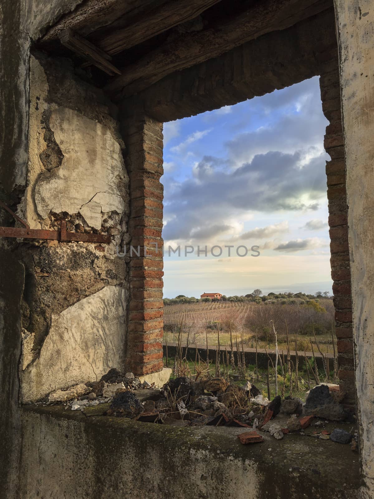 An old abandoned window showing the rural background outside. Catania, Sicily, Italy