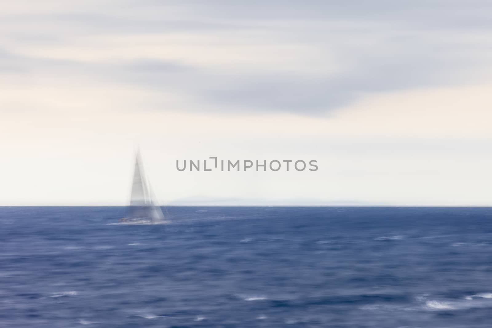 A calm and suggestive scenario with a sailboat navigating at sunset