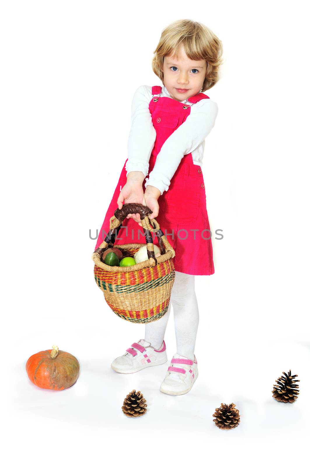 little girl standing with basket full of vegetables