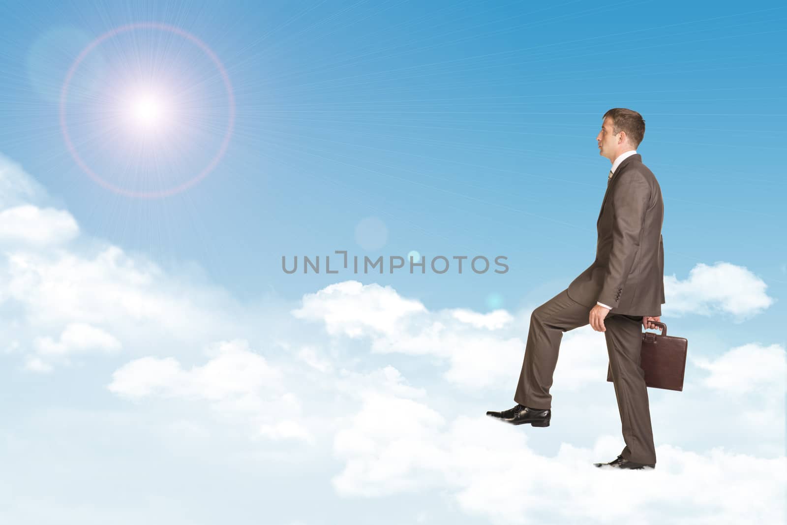 Businessman in suit with briefcase walking on cloud. Sky with sun as backdrop