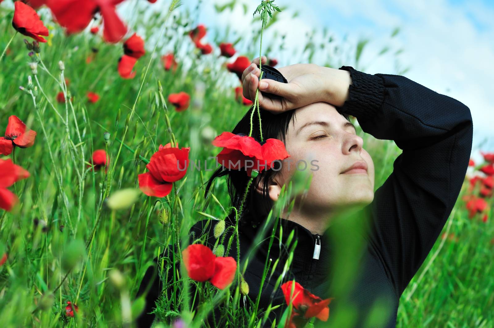 brunette young woman relaxing in the poppies field