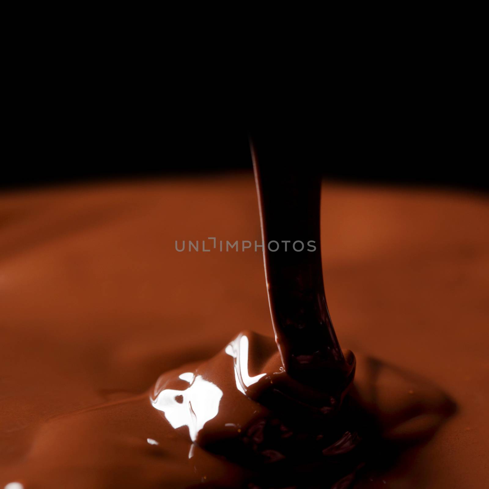 Hot melted chocolate flow on dark background
