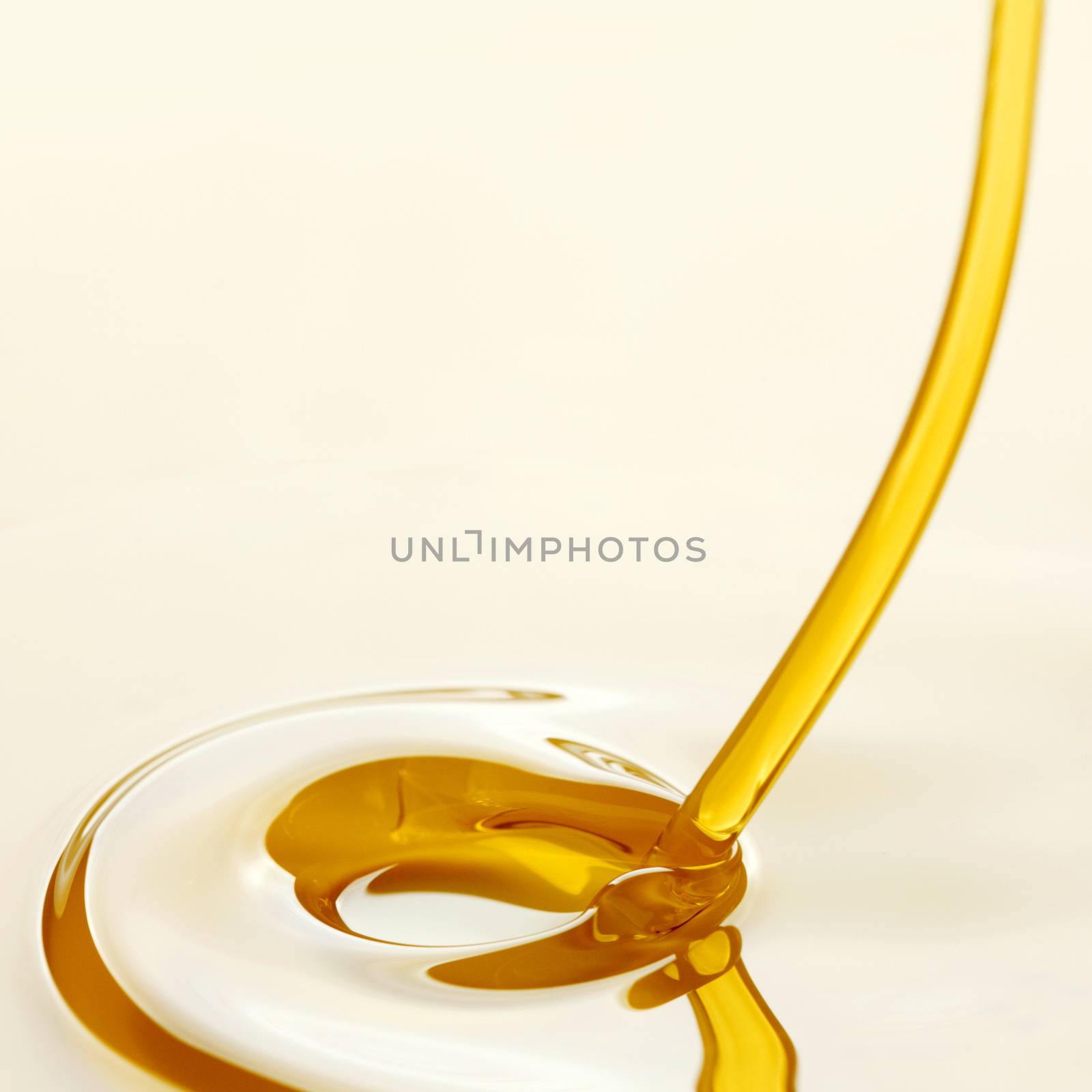 Pouring liquid golden oil close up view