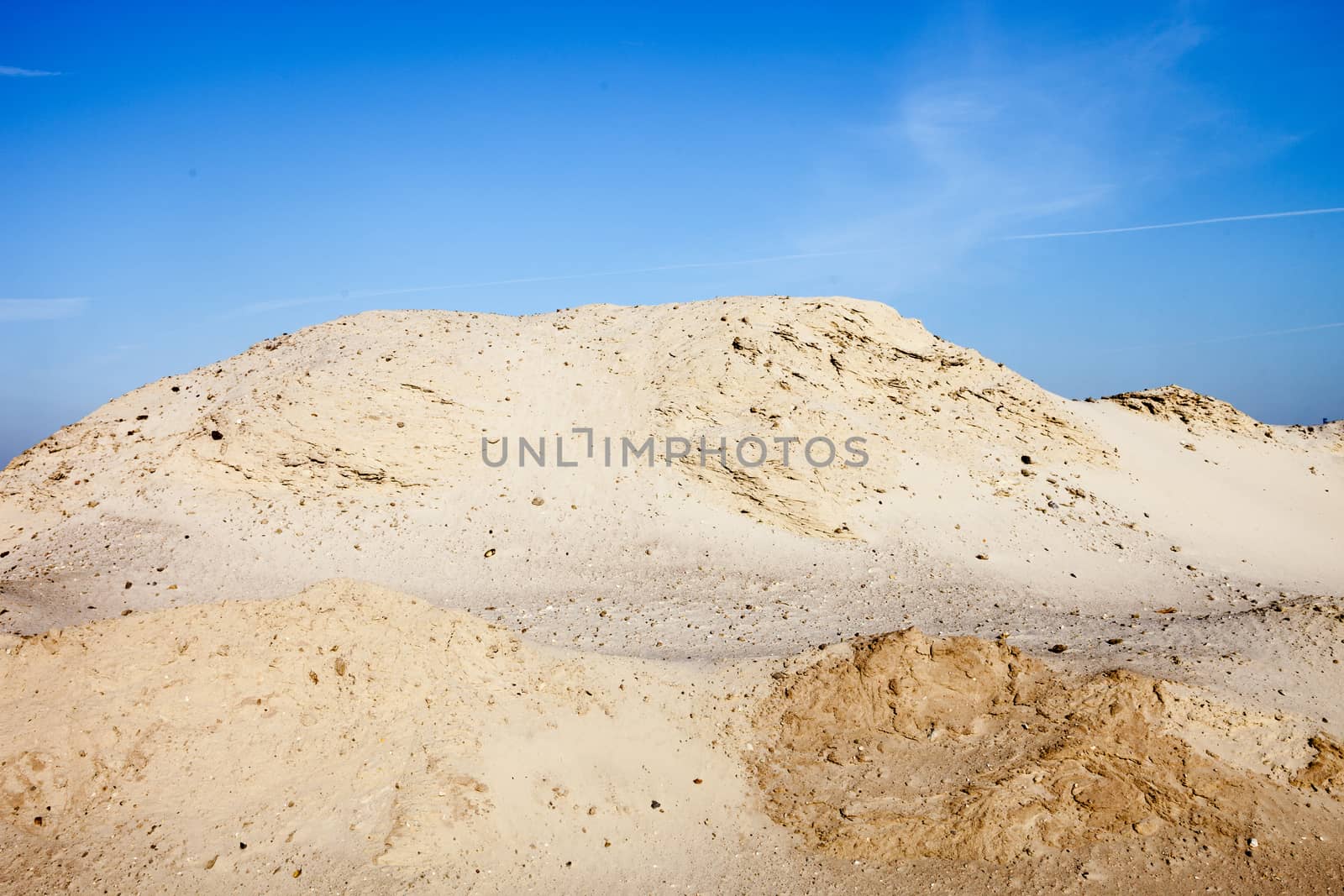 Pile of sand and blue sky over it.