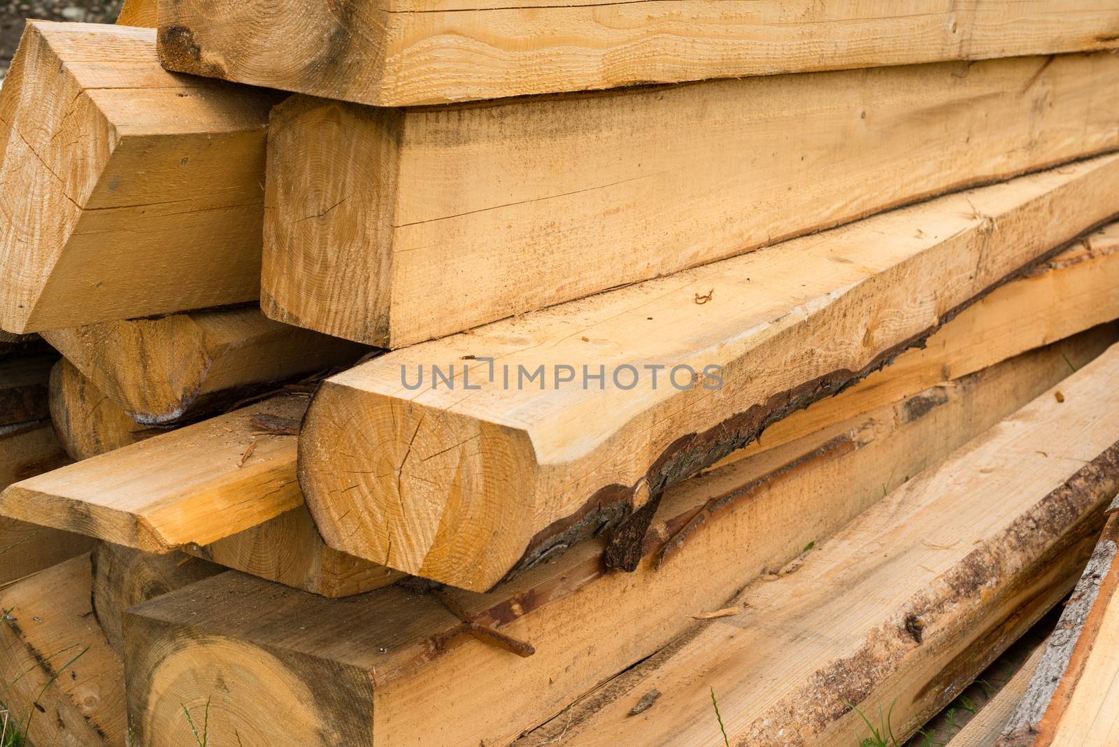 Pile of wooden beams in the construction site. Close up.