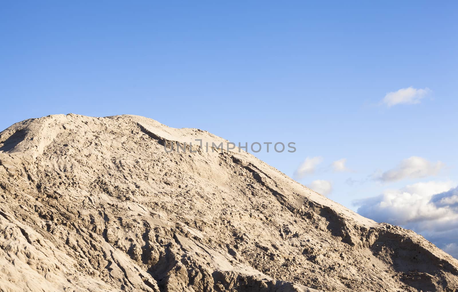 Pile of sand and blue sky over it.