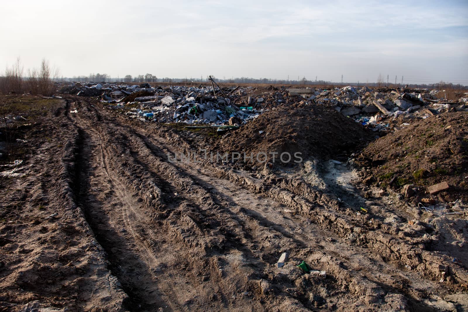 Piles of garbage on the city landfill near the dirt road