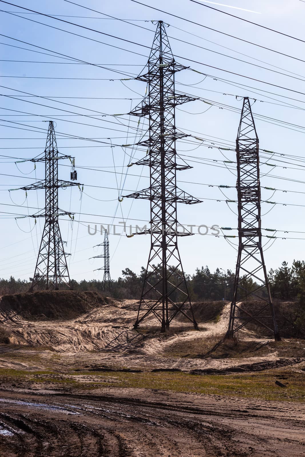 System of electricity pylons and power lines out-of-town by rootstocks