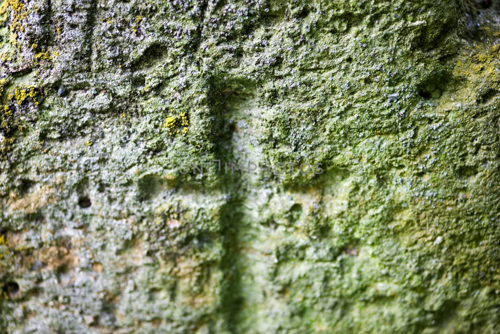 Engraved cross on the old stone surface. Close up. 