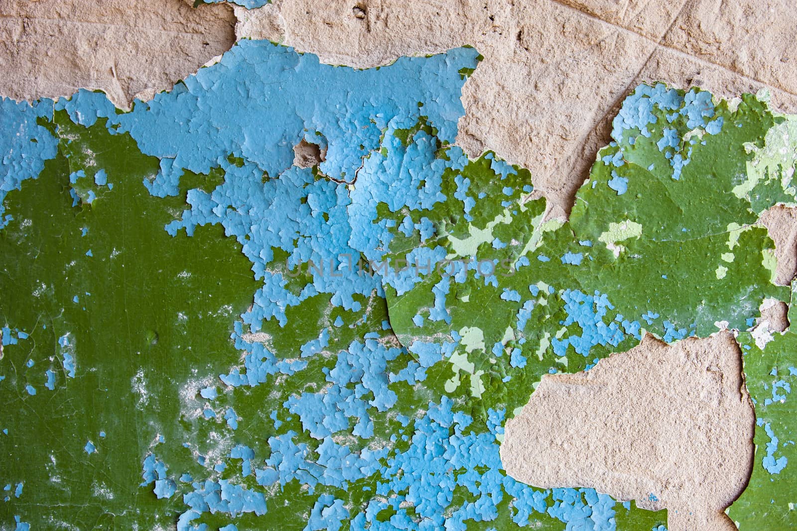 Old wall with rich texture of the cracked blue and green paint